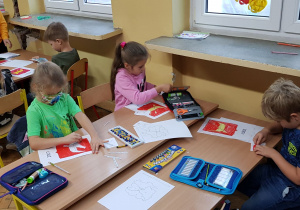 Grupa uczniów koloruje herby Łodzi
